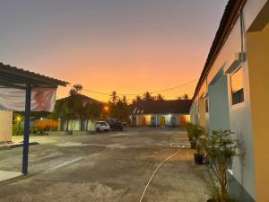 Una vista del atardecer desde el estacionamiento de un motel. en โรงแรมเมโทร2 Metro2, en Satun