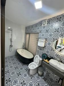a bathroom with a tub and a toilet and a sink at Azalea Tam Coc Ninh Bình in Ninh Binh