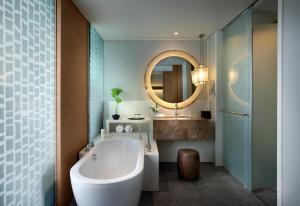 港生Rayong Marriott Resort & Spa的带浴缸、水槽和镜子的浴室