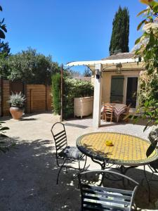 d'une terrasse avec une table et des chaises dans la cour. dans l'établissement Le Mazet de Louise, à Saint-Rémy-de-Provence