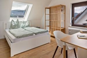 - une chambre avec un lit, un bureau et une table dans l'établissement Ferienwohnung Kühn, à Kirchzarten
