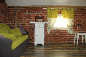 uma sala de estar com um sofá e uma parede de tijolos em Domek Podróżniczy em Lódź
