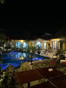 un complexe avec une piscine ouverte la nuit dans l'établissement Azalea Tam Coc Ninh Bình, à Ninh Binh