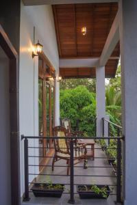 eine Veranda eines Hauses mit einem Stuhl darauf in der Unterkunft Lion Gate Hotel Sigiriya in Sigiriya