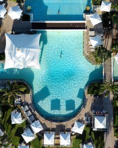 uma vista sobre uma piscina com guarda-sóis brancos em Sheraton Grand Mirage Resort Gold Coast em Gold Coast