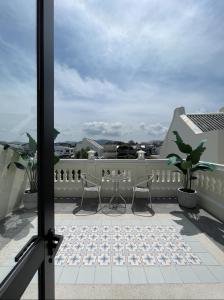 een balkon met 2 stoelen en een tafel bij Hawa House Phuket in Phuket