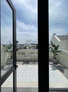 een raam met uitzicht op een balkon bij Hawa House Phuket in Phuket