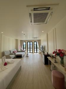 een grote woonkamer met een bed en een bank bij Hawa House Phuket in Phuket