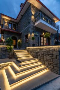 une maison en pierre avec des escaliers en face de celle-ci dans l'établissement FLOARA DI MUNTE Forest Luxury Suites, à Metsovo