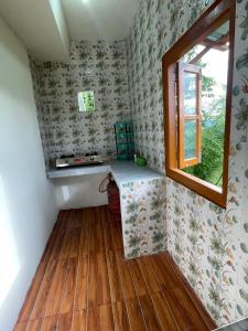 a small room with a desk and a window at Mountaintop Guest House in Bhurtuk