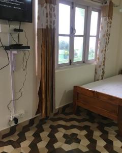 1 dormitorio con cama y ventana en Mountaintop Guest House, en Bhurtuk