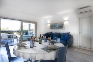 a dining room with a table and a blue couch at Sardinia Gold Luxury Apartment in Palau