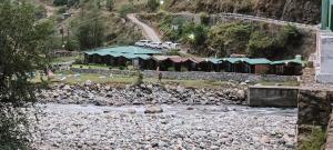 a view of a river with a group of buildings at Jayara Resort And Cafe in Barkot