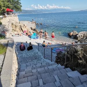 eine Gruppe von Menschen an einem Strand in der Nähe des Wassers in der Unterkunft Apartman Surić in Novi Vinodolski