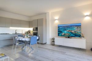 Sardinia Gold Luxury Apartment في بالاو: مطبخ وغرفة طعام مع طاولة وكراسي