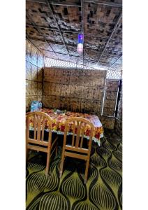 BelparāoにあるCorbett Madhavi Homestayのテーブルと椅子2脚(テーブル席付)