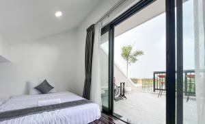 a bedroom with a bed and a sliding glass door at Angkearboss Villa in Kampot