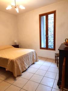 a bedroom with a bed and a window at L'ase et la tuca in Bessan