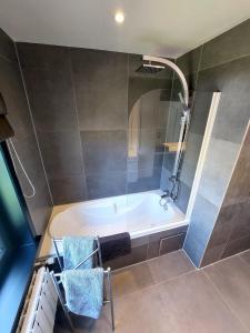 a bathroom with a bath tub with a shower at The White Villa in Blankenberge