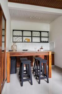 een keuken met een grote houten tafel en krukken bij 26# 2 bed Parq Ubud in Ubud