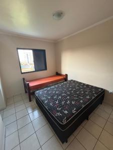 Un dormitorio pequeño con una cama y una ventana. en Apartamento beira-mar em Mongaguá, en Mongaguá