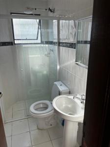 Un baño con ducha, inodoro y lavabo. en Apartamento beira-mar em Mongaguá, en Mongaguá