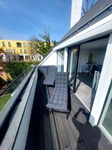 una terrazza in legno con due sedie su una casa di The White Villa a Blankenberge