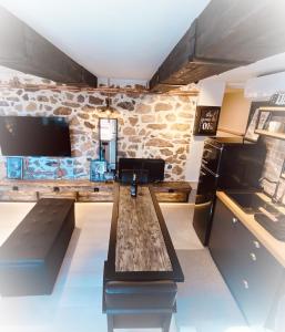 sala de estar con mesa y pared de piedra en calm stone house elemm, en Kastoria
