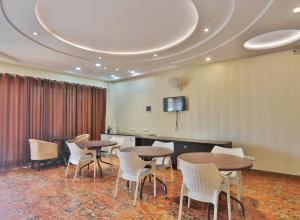 een vergaderruimte met tafels en stoelen en een tv bij Hotel Aarya in Lucknow +28 foto's