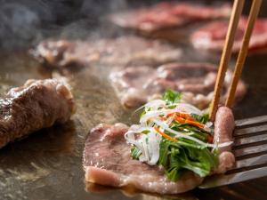 un montón de carne en una parrilla con un tenedor en Kamenoi Hotel Tsukubasan en Tsukuba
