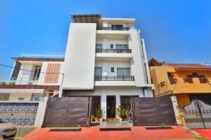 een wit gebouw met een hek ervoor bij Hotel Aarya in Lucknow