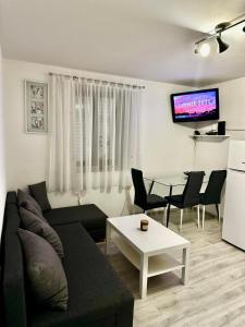 un soggiorno con divano e tavolo di Apartma JUGO a Capodistria