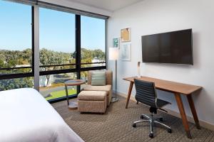 um quarto de hotel com uma secretária e uma televisão em Element Santa Clara em Santa Clara