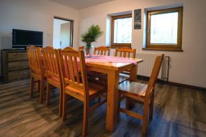 a dining room with a wooden table and chairs at Chata Dolný Smokovec Správa TANAPu in Starý Smokovec +9 photos