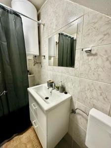 bagno bianco con lavandino e specchio di Apartma JUGO a Capodistria