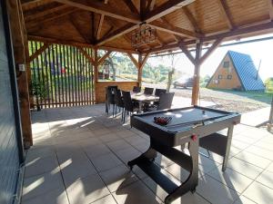 a ping pong table on a patio with a table and chairs at Rock Valley Cabins in Ibăneşti