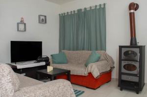 a living room with a couch and a tv at Eleni's Home 