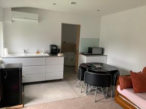 eine Küche mit Spüle und Tisch in einem Zimmer in der Unterkunft Le Rouet in Ytres