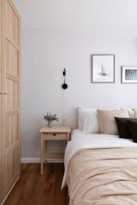 a white bedroom with a bed and a table at AirTLV - Arlozorov Apartment's in Tel Aviv