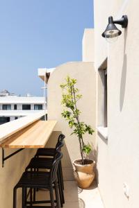 een tafel en stoelen op een balkon met een potplant bij AirTLV - Arlozorov Apartment's in Tel Aviv