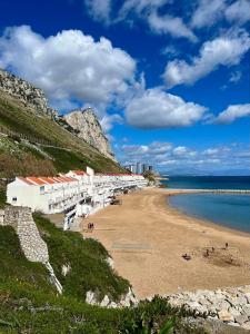 - une plage avec un tas de bâtiments et l'océan dans l'établissement Beach Front Apartment, à Gibraltar