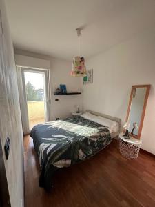 een slaapkamer met een bed, een spiegel en een raam bij CASA GIULIA in Pescara