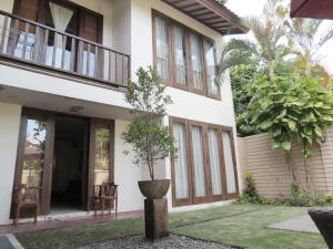 a house with a potted tree in front of it at Sekuta Condo Suites in Sanur