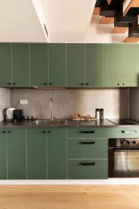a kitchen with green cabinets and a sink at AirTLV - Arlozorov Apartment's in Tel Aviv