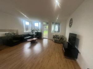sala de estar con sofá y TV en North London A spacious 7 bedroom house accommodating up to 18 people complete with own gym and table tennis en Londres