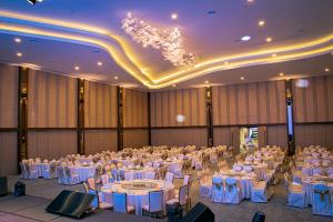 un gran salón de banquetes con mesas y sillas blancas en Theatre Hotel en Kuching