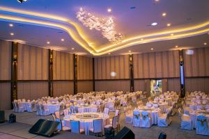 a large banquet hall with white tables and chairs at Theatre Hotel in Kuching