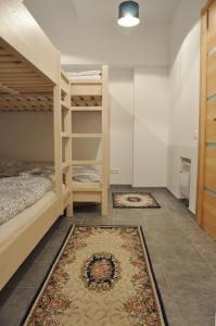 a bedroom with two bunk beds and a rug at Bomb Shelter apartment in Vilnius