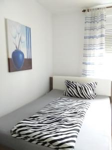 a zebra print bed in a bedroom with a window at Pension Breidbach in Ensch