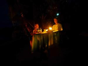 um homem e uma mulher sentados à mesa com uma vela em Ravita Cove HomeAway from Home HomeStay em Matacawalevu